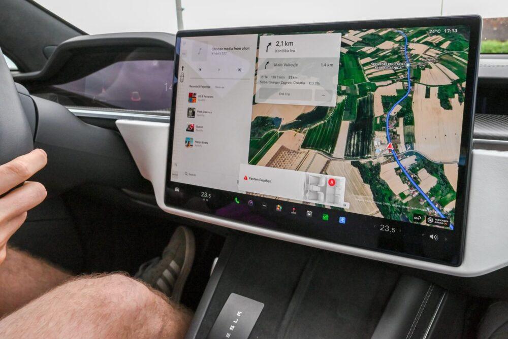 Inside view of a car with a large navigation screen and detailed digital map.