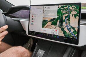 Inside view of a car with a large navigation screen and detailed digital map.