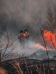 3 men in black jacket and black pants playing with fire